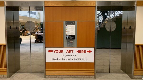 Image of Mann elevators with "Your Art Here" signage for elevator art contest