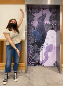Student artist Elizabeth Hughes standing in front of elevator design
