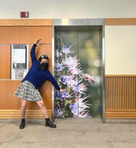 Student artist Wenjia Zong standing in front of elevator design