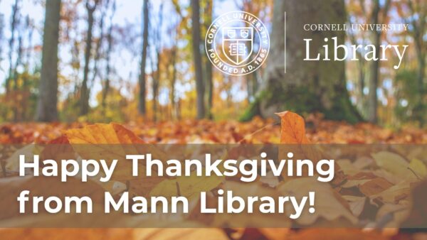 Autumn forest floor covered in fallen leaves with a banner reading “Happy Thanksgiving from Mann Library” and the Cornell University Library logo.