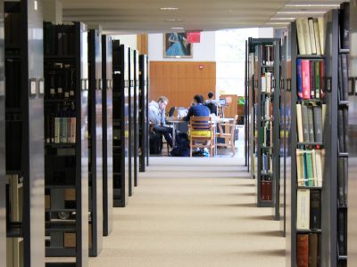 Image of Mann library stacks and students studying
